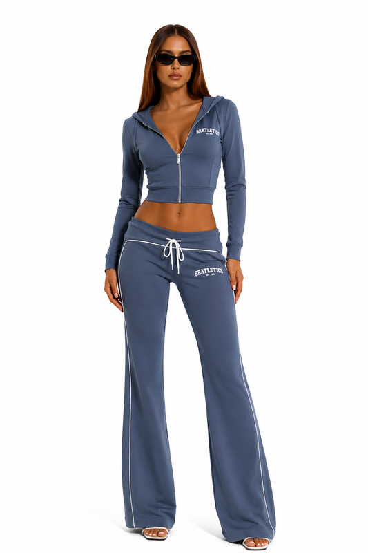 Woman wearing a blue tracksuit with a visible brand logo on a white background