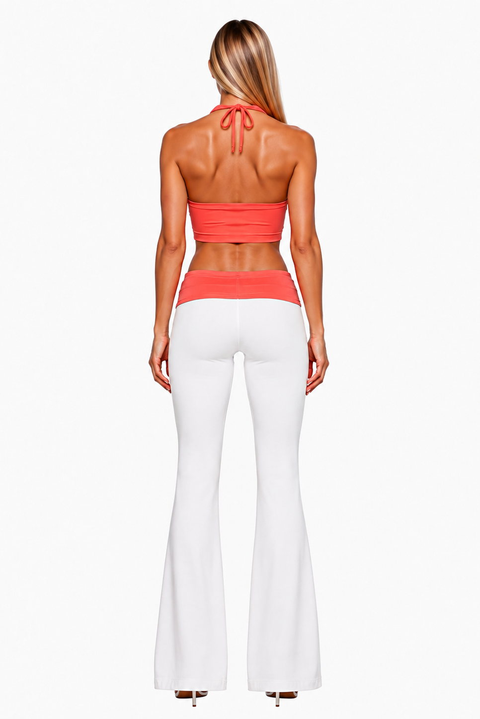 A woman shown from the back wearing a coral halter crop top and white flared pants against a light gray studio background.