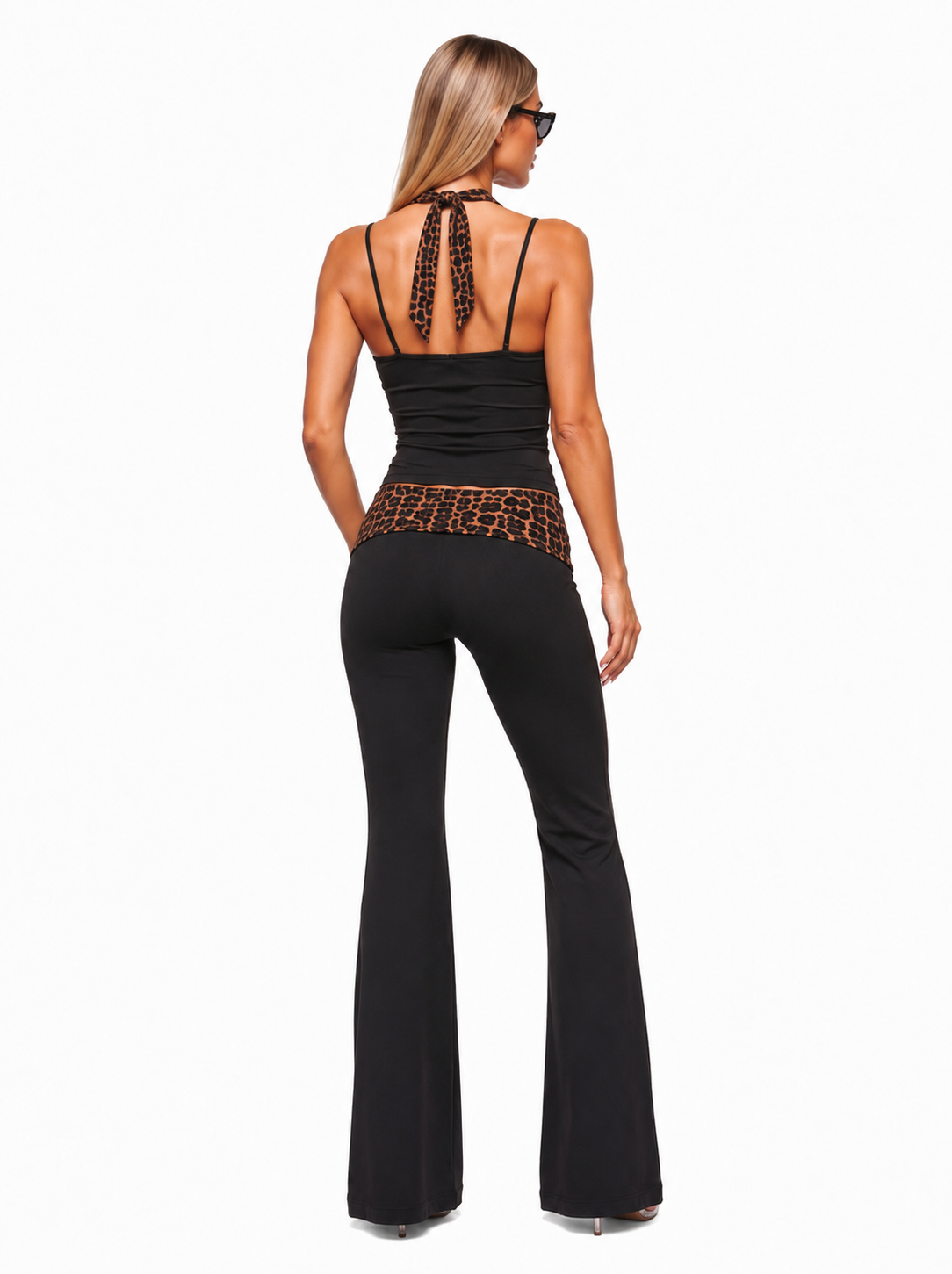 Woman wearing a black jumpsuit with leopard print details on a white background